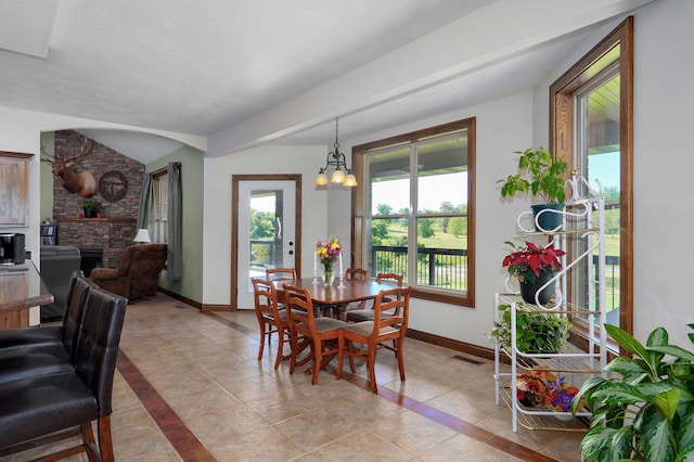 7519 W Farm Rd Unit 194, Republic, MO 65738 - dining area with a stone fireplace, baseboards, light tile patterned floors, and a chandelier