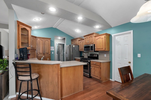 382 S Yellowwood Dr, Springfield, MO 65809 - kitchen with stainless steel appliances, lofted ceiling, a peninsula, dark wood-type flooring, and light countertops
