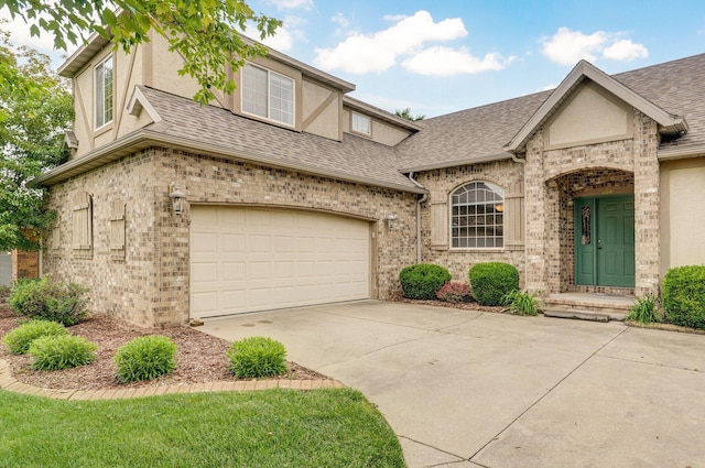 382 S Yellowwood Dr, Springfield, MO 65809 - view of front of home featuring roof with shingles, a garage, brick siding, driveway, and stucco siding