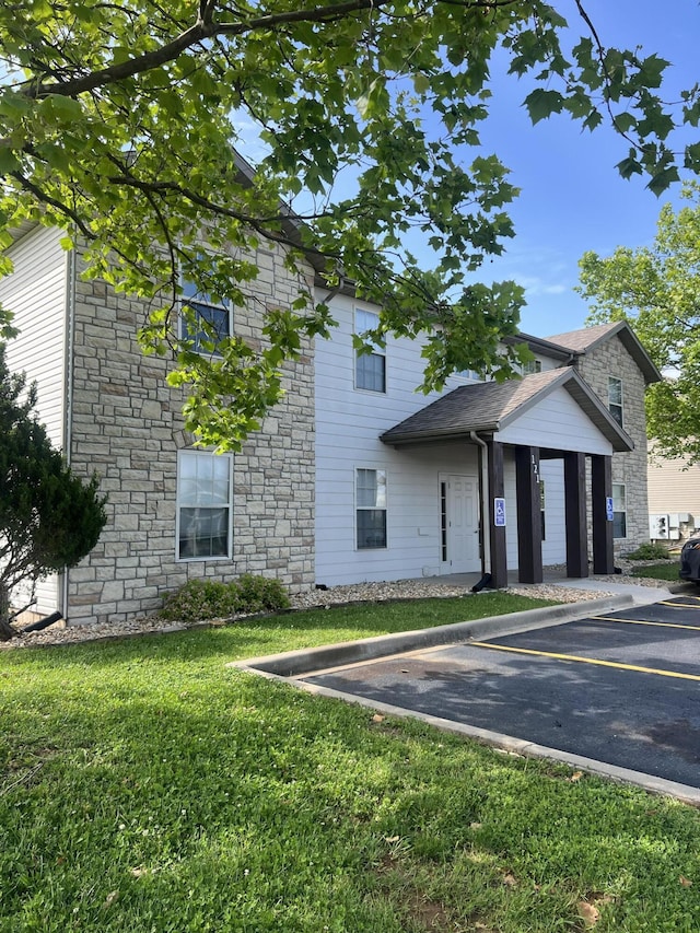 121 Toni Ln Unit 1-4, Branson, MO 65616 - view of front facade with stone siding, uncovered parking, and a front yard