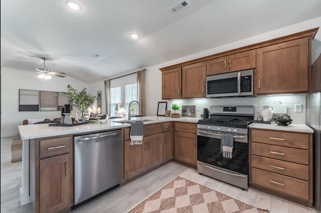 1108 W Pebblebrooke Dr, Ozark, MO 65721 - kitchen with appliances with stainless steel finishes, a peninsula, vaulted ceiling, light countertops, and decorative backsplash