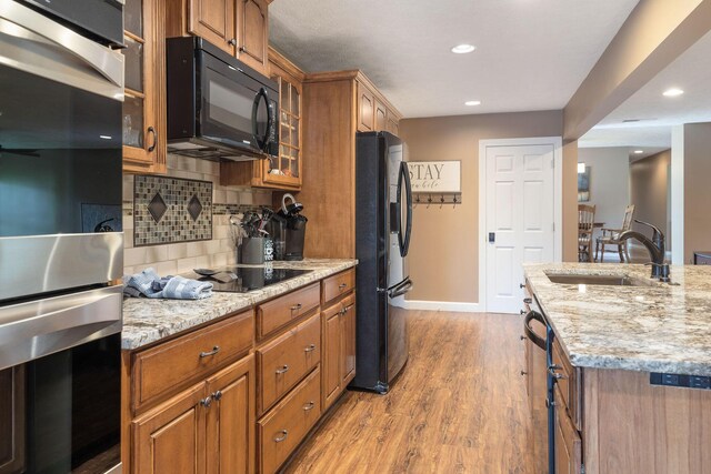 1394 Bee Creek Rd, Branson, MO 65616 - kitchen featuring black appliances, a sink, light wood-style flooring, brown cabinets, and recessed lighting