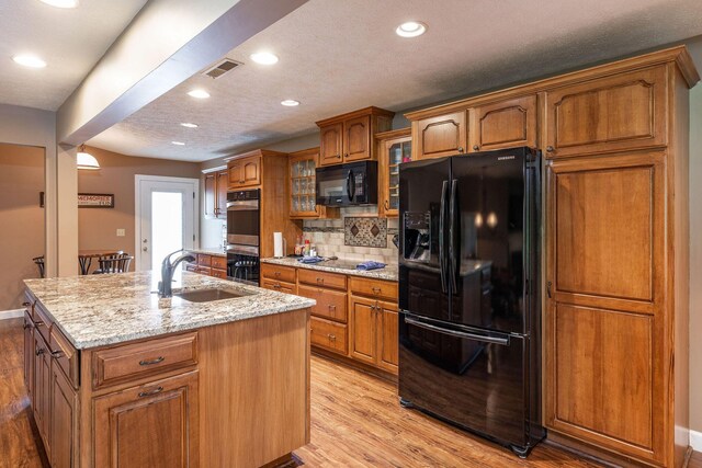 1394 Bee Creek Rd, Branson, MO 65616 - kitchen with black appliances, a sink, brown cabinets, light wood finished floors, and recessed lighting