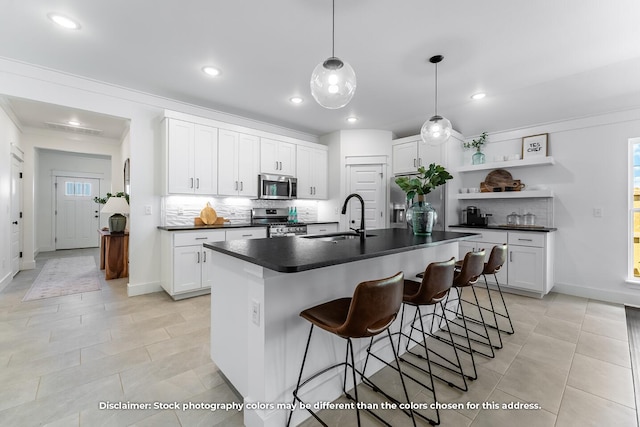 1106 W Pebblebrooke Dr, Ozark, MO 65721 - kitchen featuring appliances with stainless steel finishes, dark countertops, open shelves, a sink, and decorative backsplash