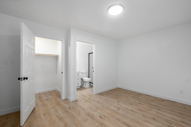 1620 N Texas Ave, Springfield, MO 65803 - unfurnished bedroom with light wood-style floors, a closet, baseboards, a walk in closet, and ensuite bathroom
