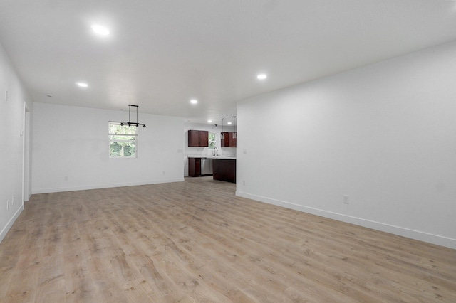 1620 N Texas Ave, Springfield, MO 65803 - unfurnished living room with recessed lighting, light wood-type flooring, and baseboards