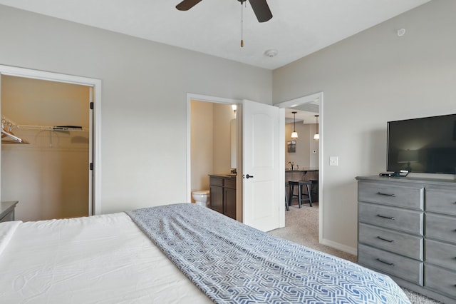 200 Majestic Dr Unit 1-208, Branson, MO 65616 - carpeted bedroom featuring a walk in closet, baseboards, ceiling fan, a sink, and ensuite bathroom