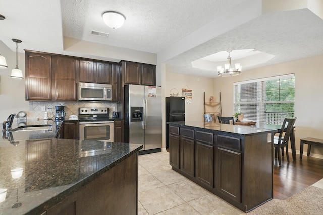 200 Majestic Dr Unit 1-208, Branson, MO 65616 - kitchen with stainless steel appliances, a sink, a raised ceiling, a textured ceiling, and tasteful backsplash