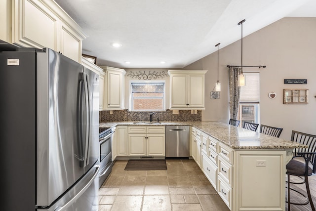 5142 S Burrows Ave, Springfield, MO 65810 - kitchen with appliances with stainless steel finishes, cream cabinetry, a peninsula, a kitchen breakfast bar, and vaulted ceiling