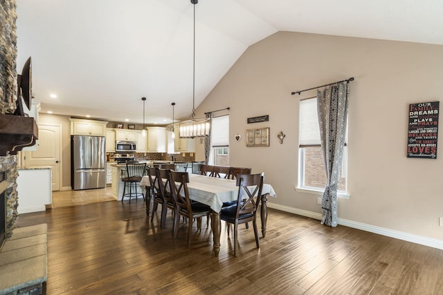 5142 S Burrows Ave, Springfield, MO 65810 - dining area featuring wood finished floors, high vaulted ceiling, recessed lighting, a stone fireplace, and baseboards
