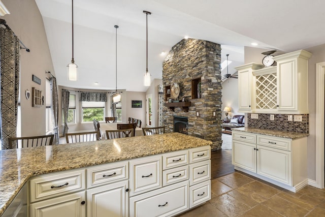 5142 S Burrows Ave, Springfield, MO 65810 - kitchen featuring high vaulted ceiling, light stone countertops, decorative light fixtures, backsplash, and open floor plan