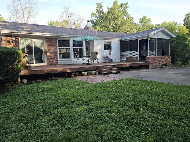 22389 Lawrence Unit 1215, Aurora, MO 65605 - rear view of property featuring brick siding, a sunroom, a deck, a lawn, and a chimney