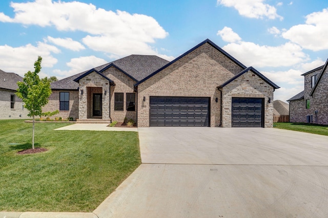 1698 N Marlowe Ave, Springfield, MO 65802 - french country style house featuring a garage, driveway, a front yard, and brick siding