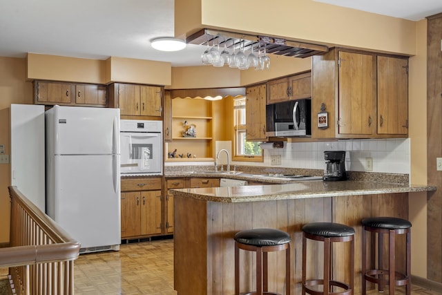 39 James River Rd, Kimberling City, MO 65686 - kitchen featuring white appliances, a sink, a peninsula, and brown cabinets
