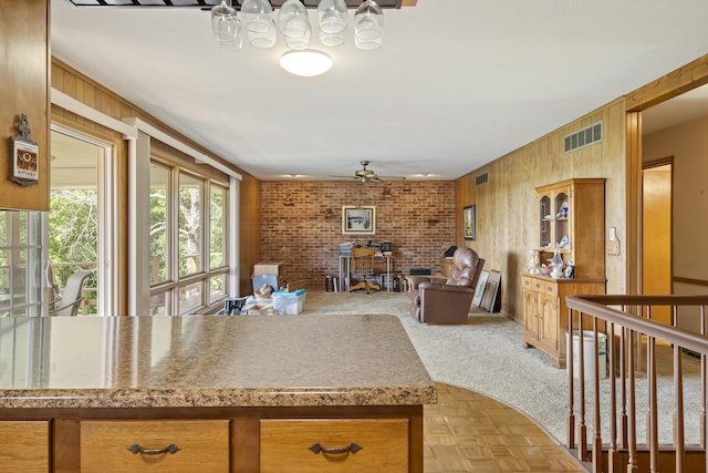 39 James River Rd, Kimberling City, MO 65686 - kitchen featuring ceiling fan, wooden walls, open floor plan, and brown cabinets