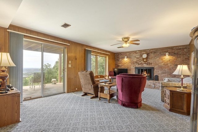39 James River Rd, Kimberling City, MO 65686 - carpeted living room featuring a ceiling fan, a fireplace, wooden walls, and brick wall