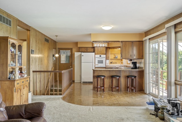 39 James River Rd, Kimberling City, MO 65686 - kitchen with white appliances, healthy amount of natural light, open shelves, brown cabinets, and wooden walls