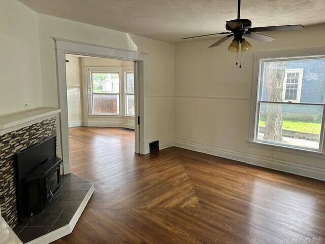 1052 S Garrison Ave, Carthage, MO 64836 - unfurnished living room with a wood stove, ceiling fan, and baseboards