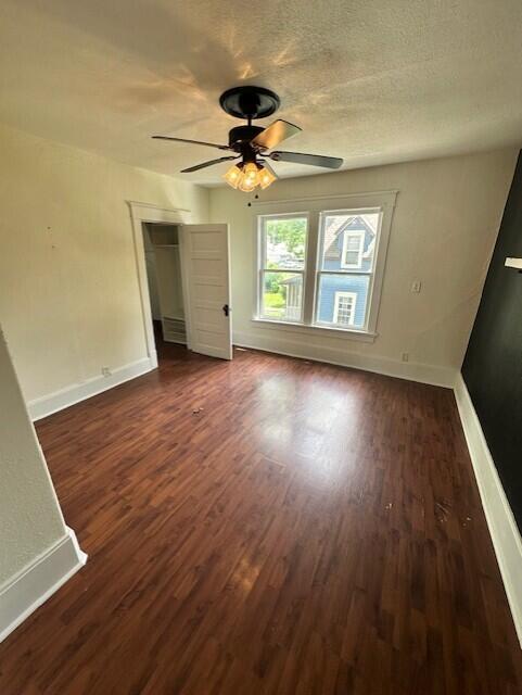 1052 S Garrison Ave, Carthage, MO 64836 - unfurnished bedroom featuring baseboards, dark wood-type flooring, a closet, and ceiling fan