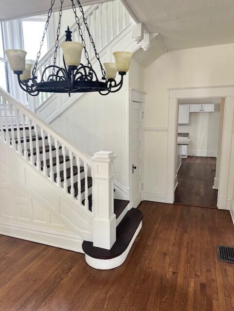 1052 S Garrison Ave, Carthage, MO 64836 - stairs featuring a chandelier, wood finished floors, lofted ceiling, and baseboards