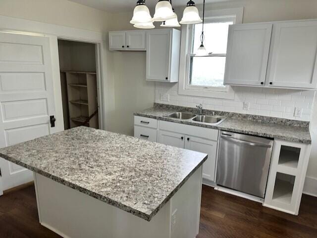 1052 S Garrison Ave, Carthage, MO 64836 - kitchen featuring stainless steel dishwasher, dark wood-style flooring, a sink, white cabinetry, and backsplash