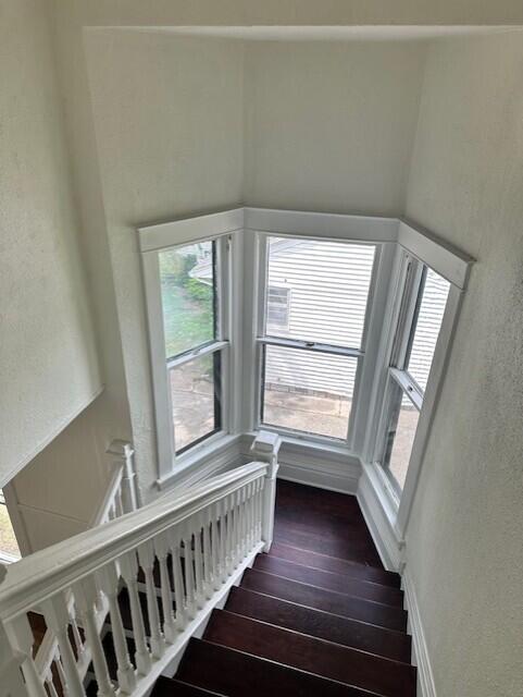 1052 S Garrison Ave, Carthage, MO 64836 - staircase featuring hardwood / wood-style flooring and a textured wall