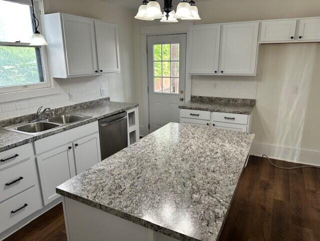 1052 S Garrison Ave, Carthage, MO 64836 - kitchen with stainless steel dishwasher, a sink, a chandelier, a kitchen island, and decorative backsplash