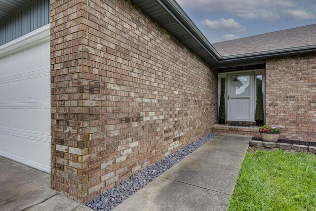 299 Regal Dr, Rogersville, MO 65742 - property entrance featuring brick siding, a shingled roof, and an attached garage