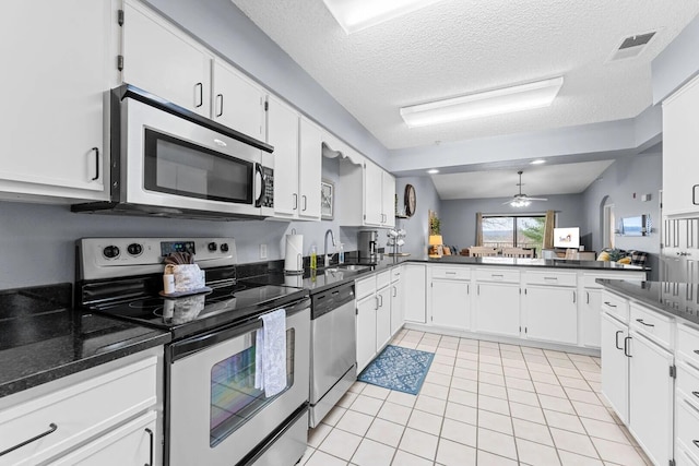 350 S Wildwood Dr Unit B-11, Branson, MO 65616 - kitchen featuring appliances with stainless steel finishes, a sink, light tile patterned flooring, white cabinets, and a textured ceiling