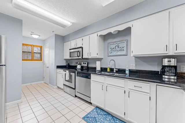 350 S Wildwood Dr Unit B-11, Branson, MO 65616 - kitchen featuring appliances with stainless steel finishes, a sink, baseboards, white cabinets, and a textured ceiling
