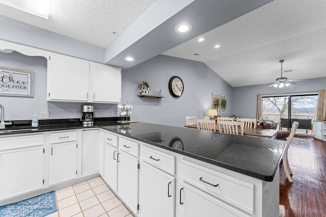 350 S Wildwood Dr Unit B-11, Branson, MO 65616 - kitchen with a sink, a peninsula, a textured ceiling, white cabinetry, and dark stone countertops