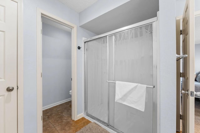 350 S Wildwood Dr Unit B-11, Branson, MO 65616 - ensuite bathroom with a stall shower, tile patterned flooring, toilet, and baseboards