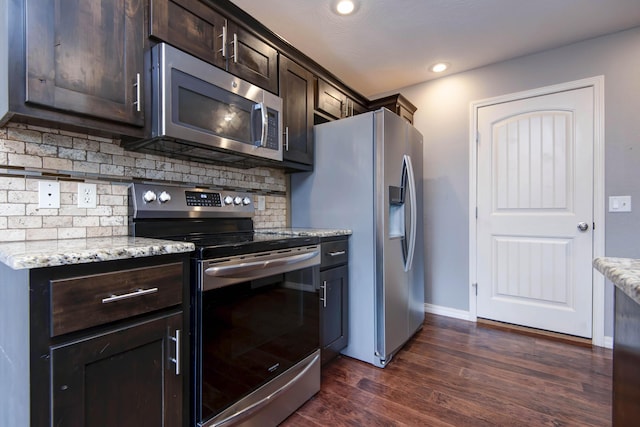 5048 S Fieldstone Rd, Battlefield, MO 65619 - kitchen with appliances with stainless steel finishes, dark brown cabinetry, decorative backsplash, dark wood-style floors, and light stone countertops