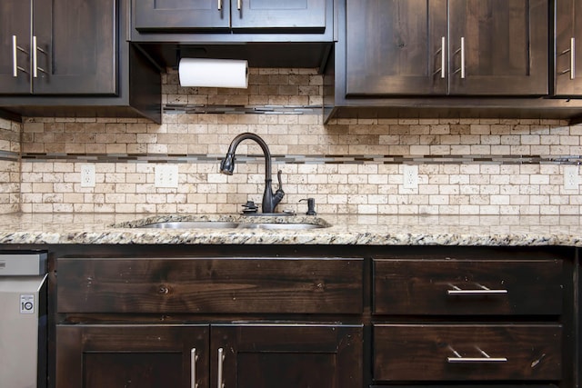 5048 S Fieldstone Rd, Battlefield, MO 65619 - kitchen with a sink, dark brown cabinetry, decorative backsplash, and light stone counters