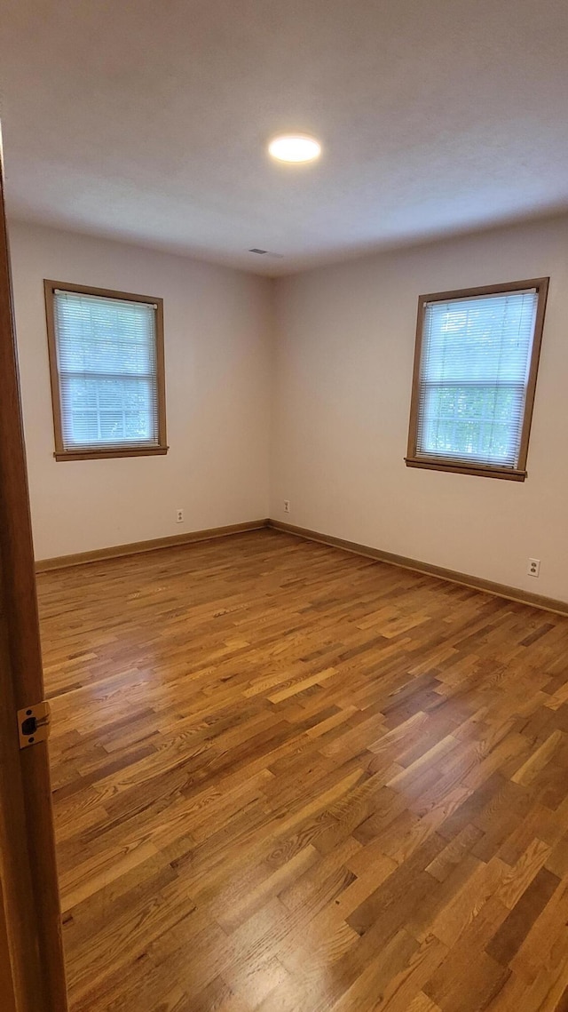 415 N Locust St, Marshfield, MO 65706 - unfurnished room with plenty of natural light, wood finished floors, and baseboards