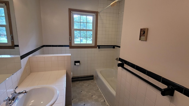 415 N Locust St, Marshfield, MO 65706 - bathroom with tile walls, a tub to relax in, a sink, toilet, and wainscoting