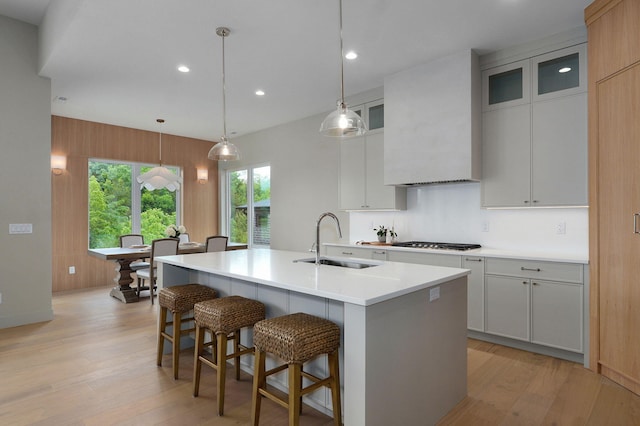 3725 E Woodhue St, Springfield, MO 65802 - kitchen featuring a sink, custom exhaust hood, light wood-style floors, a breakfast bar area, and recessed lighting
