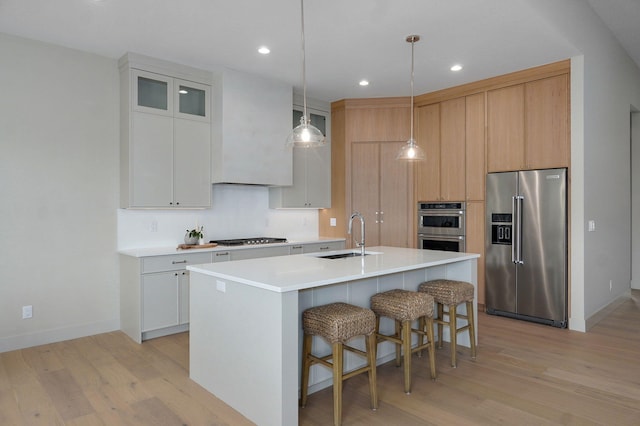 3725 E Woodhue St, Springfield, MO 65802 - kitchen featuring stainless steel appliances, a sink, light wood-style flooring, a center island with sink, and recessed lighting