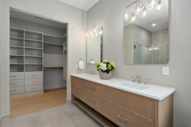 3725 E Woodhue St, Springfield, MO 65802 - bathroom featuring double vanity, a shower with shower door, wood finished floors, a walk in closet, and baseboards