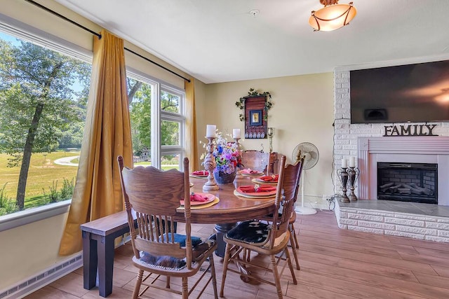 360 Cathy St, Branson, MO 65616 - dining room featuring baseboard heating, a fireplace, baseboards, and wood finished floors