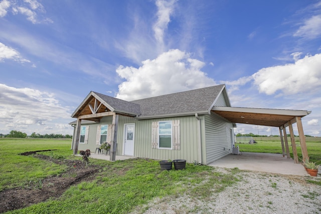 13447 E 1424th Rd, Stockton, MO 65785 - view of front of house featuring an attached carport, a front lawn, roof with shingles, and board and batten siding