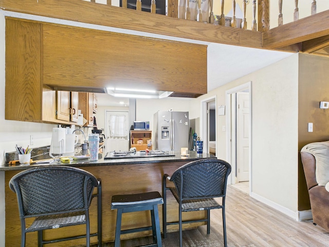 54 Southgate Dr, Harrison, AR 72601 - kitchen featuring appliances with stainless steel finishes, dark countertops, a peninsula, light wood-type flooring, and baseboards