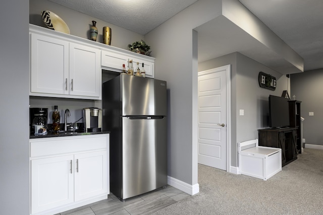 994 S Cumberland Ave, Republic, MO 65738 - kitchen with freestanding refrigerator, white cabinets, baseboards, and dark countertops