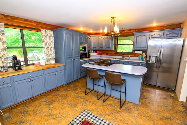 1288 County Road 334, Tecumseh, MO 65760 - kitchen with stainless steel appliances, a sink, light countertops, a center island, and a breakfast bar