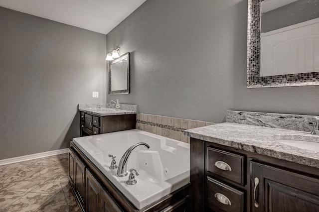 3383 Lusk Dr, Neosho, MO 64850 - full bath with marble look tiles, two vanities, a jetted tub, baseboards, and a textured wall