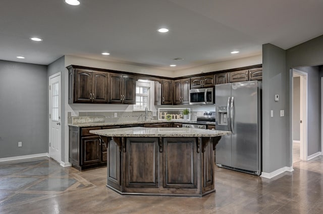 3383 Lusk Dr, Neosho, MO 64850 - kitchen featuring appliances with stainless steel finishes, dark brown cabinetry, baseboards, recessed lighting, and a kitchen breakfast bar