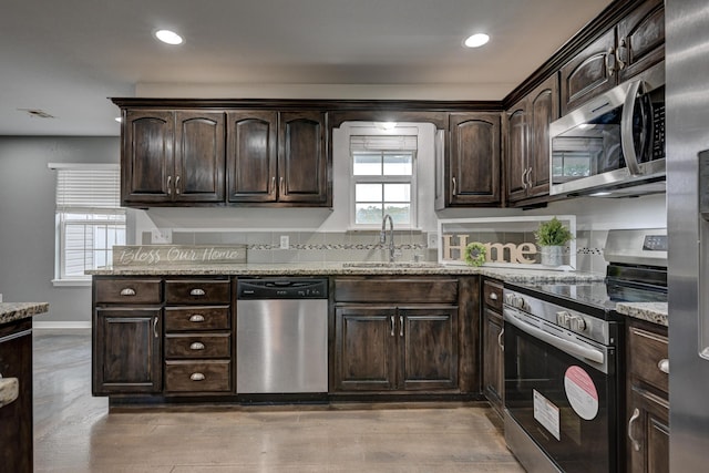 3383 Lusk Dr, Neosho, MO 64850 - kitchen with appliances with stainless steel finishes, a sink, dark brown cabinets, light stone countertops, and recessed lighting