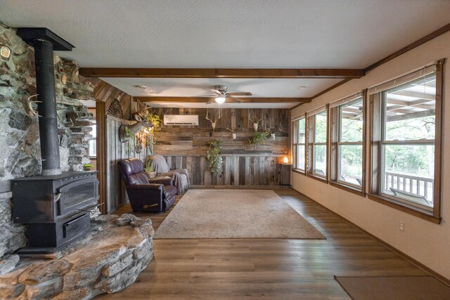 651/TBD Round Robin Ln, Yellville, AR 72687 - unfurnished living room featuring a wood stove, wood finished floors, wood walls, beamed ceiling, and a wall mounted AC