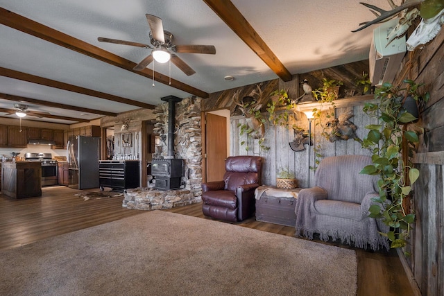 651/TBD Round Robin Ln, Yellville, AR 72687 - living room with a wood stove, ceiling fan, dark wood-style flooring, and beamed ceiling