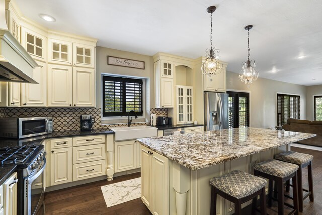 807 S Stanford Dr, Rogersville, MO 65742 - kitchen with cream cabinetry, appliances with stainless steel finishes, a sink, decorative backsplash, and recessed lighting